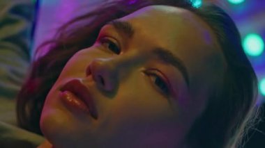 Çekici kadın Neon Funfair atlıkarınca pozu veriyor dikey çekim yakın çekim. Aydınlanmış eğlence parkında muhteşem bir model hafta sonu dinleniyor. Tatil randevusundaki romantik kız. Şenlikli bayan.