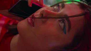 Üzgün, konuşan cep telefonlu, dikey yakın çekim. Başarısız bir randevuda mutsuz bir kızın son araması. Hüsrana uğramış üzgün model arkadaşlarının yalnız hissetmesini bekliyor. Aydınlanmış Ay Parkı 'nda bir kadın dinleniyor.