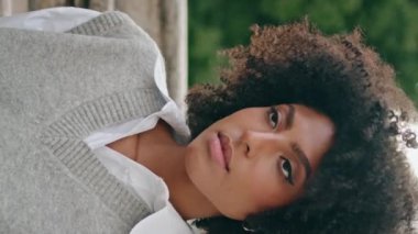 Kendine güveni tam bir kadın merdivenlerde rahatlar güzel bir gün yakın yürür. Süper sakin Afro-Amerikan kız portresi merdivenlerde oturmuş şık bir şekilde dikey bir görünüm takınıyor. Seyahat eğlence konsepti