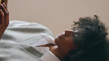Uzaktan kumandalı sörf yapan, rahat kafeye yakın oturan biri. Düşünceli Afrikalı Amerikalı kadın bilgisayar üzerinde çalışıyor. Gerekçesiz yere yorgun. Ev yapımı dikey çekimde çok çalışan iş kadını sorunu çözüyordu.