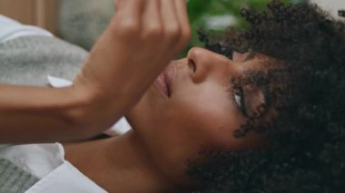 Samimi kafede kokteyl içen hayalperest kadın. Yakın plan. Dalgalı Afrikalı Amerikalı kıvırcık kız restoranda tek başına oturmuş samanla lezzetli bir içki tadıyor. Rahatlamış bayan, içecek videosunun keyfini çıkarın..