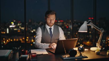 Şirket çalışanı gece geç saatlerde iş yerinde çok çalışıyor. Şehir merkezinde dizüstü bilgisayarda çalışan profesyonel çalışan bir işçi. Orta yaşlı satış müdürü raporları analiz ediyor.