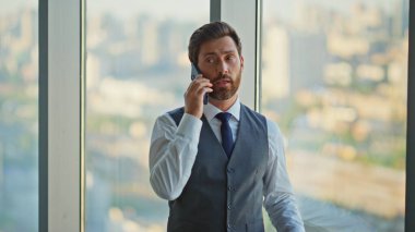 Tecrübeli bir yönetici cep telefonuyla konuşuyor. Finans müdürü telefonda pazarlık yapıyor. Şehir merkezinde iş görüşmesi yapıyor. Çağdaş ofiste başarılı bir orta yaşlı girişimci danışma istemcisi