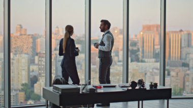 Şirket iş arkadaşları akşam kentinde kahve molası veriyor. Panoramik şehre hayran olan iş ortakları, çağdaş ofiste gelecekteki proje gelişimini tartışıyor. Yönetim insanları kavramı