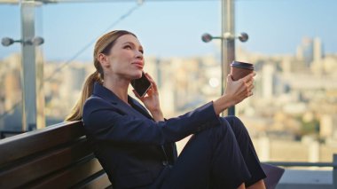 Rahat iş kadını cam terasta akıllı telefonu arıyor. Gülümseyen müdür ofis balkonunda çıplak ayakla şehir manzarasında kahve içerken dinleniyor. Cep telefonu sohbetine ara veren başarılı işçi.