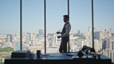 Erkek silueti dinlenme odası panoramik pencere gibi görünüyor. Finans Müdürü, masa başı işyerinde iş görüşmesi yapmayı düşünüyor. Şehir binalarını düşünceli profesyonel planlama.
