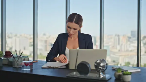 Busy woman study documents in panoramic office. Company lawyer executive signing papers checking contract at desk. Elegant successful businesswoman working reading financial report at cityscape view.