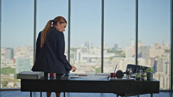 Peaceful businesswoman enjoying calm break at desk. Office woman checking cell phone reading message. Beautiful finance manager sitting barefoot looking panoramic cityscape. Tired director resting
