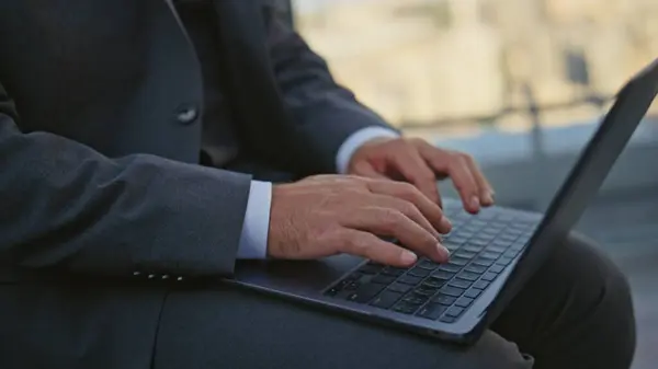 Manager hands typing keyboard closeup. Urban businessman in suit work laptop on glass terrace. Unrecognized corporate man worker using computer search information online. Remote freelancer browsing
