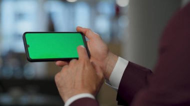 Yakın plan el, birlikte çalışırken yatay kromakey hareketli kaydırma. Kimliği belirsiz adam yeşil ekran cihazında haberlere bakıyor. İsimsiz yönetici ofiste dinleniyor. Patron parmak ekranına dokunuyor