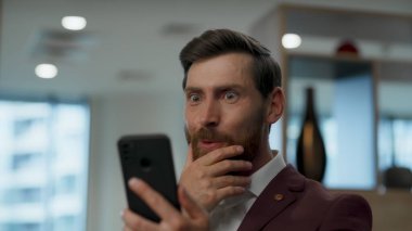 Gülümseyen girişimci açık alanda cep telefonunu merak ediyor. Şaşırmış yönetici video görüşmesinden bahsediyor. Neşeli iş adamı modern iş yerinde akıllı telefon sohbetinden keyif alıyor. İletişim konsepti