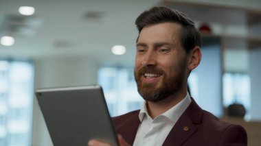 Ofisin iç mekanında eğlenen aşırı mutlu şef. Neşeli duygularla tablet izleyen hoş bir girişimci. Mutlu üst yönetici gülüyor. Çekici iş adamı dinlenme yerinde harcama molası verdi.