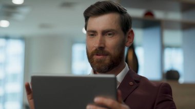 Lobideki bilgisayar ekranına el sallayan mutlu iş adamı. Müşteriyle yakın plan profesyonel bir görüşme. Kendine güvenen öğretmen, tablet webinar kaydediyor. İş teknolojileri kavramı 