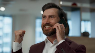 Ofis binasının CEO 'suna yakın çekim sürpriz oldu. Mutluluktan uçan iş adamı başarının heyecanını dile getiriyor. Zaferi kutlayan çok mutlu menajer işteki mutlu haberlerin tadını çıkarıyor. Zafer konsepti 