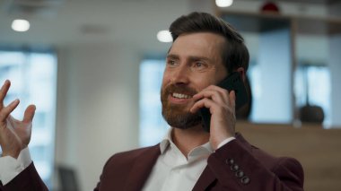 Gülen işadamı kabinede akıllı telefondan konuşuyor. Çok mutlu üst düzey yönetici başarılı bir cep telefonu görüşmesini sonlandırıyor. CEO 'nun yalnız başına iyi bir konuşma yaptığından eminim. Akıllı yönetici yeni başarıları 