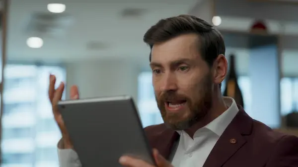 Unhappy worker shocked gadget breakdown at office. Closeup furious entrepreneur looking tablet with operational problems alone. Frustrated angry man getting bad news reading computer device