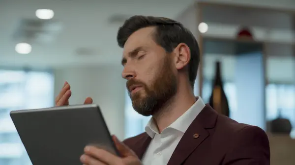Disappointed employee face palming at lobby closeup. Nervous business man solving problems alone. Worried manager watching tablet screen with sad emotion. Upset ceo thinking about project failure