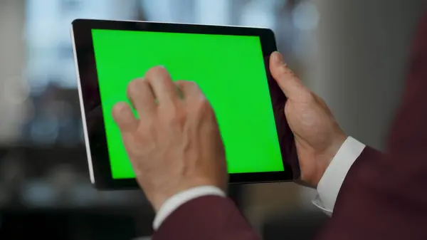 Unknown boss reducing objects at mockup tablet in lounge room. Closeup business man arms touching digital device green screen indoors. Unrecognizable person using chroma key computer at open space