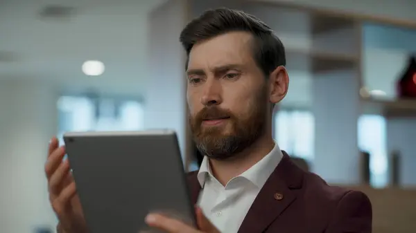Irritated boss arguing tablet at coworking closeup. Nervous ceo having problem with broken pad. Angry businessman looking watching screen, reading bad news in email. Frustrated man confused by error