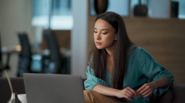 Ofisteki video konferansında açıklama yapan genç bir işletme öğretmeni. Akıllı kadın ortaklara dizüstü bilgisayar arıyor. Webinar 'daki bilgisayar kamerasıyla odaklanmış girişimci konuşması. Çevrimiçi öğretim kavramı