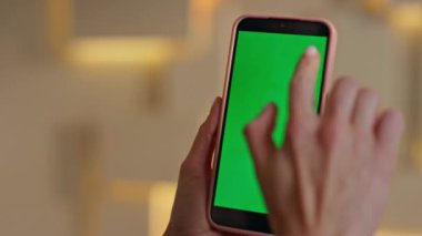 Yaratıcı stüdyodaki yeşil ekranlı cep telefonunu kapat. Bilinmeyen kadın şirket ofisinde yeşil ekran akıllı telefona dokunuyor. İş kadını model cep telefonu tarama uygulamasını çalıyor.