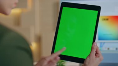 İş yeri yaratıcı stüdyosunun krom anahtar tabletine girişimci arama projesi. Kapatın. Kimliği belirsiz iş kadını yeşil ekran bilgisayarından araklıyor. Kadın elleri ofiste dijital model cihazı tutuyor..