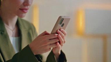 İş kadını iş yerinde cep telefonuna mesaj atıyor. Kapatın. Modern ofisteki akıllı telefondan kendine güvenen güzel bir kadın mesajlaşıyor. Sakin bayan yönetici cep telefonu uygulaması kullanarak online sipariş veriyor.