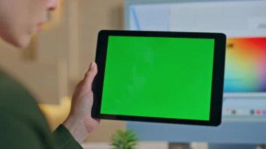 Tasarım stüdyosunda çalışan tanınmayan bir işçinin taklit tabletini kapatması. Çalışan kadın elleri ofisteki yeşil ekranlı bilgisayara dokunuyor. İş kadını internette krom anahtar aygıtı kullanarak sörf yapıyor