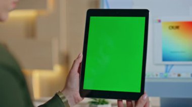 Yaratıcı ofisteki Mockup Tablet 'in e-postalarını kontrol eden yönetici. Tasarım stüdyosunda çalışan yeşil ekranlı bilgisayara bakan tanınmayan bir kadın. Krom anahtar dijital aygıtı tutan kadın elleri