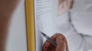 Kozmetik işlemler için bilinmeyen bir kadın klinikte dikey olarak uzman olarak oturuyor. Tanımlanamayan bayan müvekkil resmi evraklarda ameliyat için anlaşma imzalıyor..