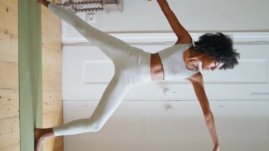 Esnek bir kadın rahat bir yerde uzanıyor. Kıvırcık saçlı sporcu yoga halısında Asana antrenmanı yapıyor. Yogi modeli dikey olarak tablet kullanılarak video eğitimi izliyor. Afrikalı kız tek başına çalışıyor. 