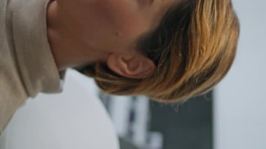Kozmetik ameliyata hazırlanan bir kadın modern güzellik kliniğinde yatarken dikey olarak yakın plan. Çekici bayan gülümseyen kamerayı cilt bakımına hazırlıyor. Müşteri bekleme danışmanlığı.