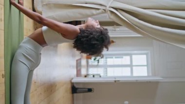 Güçlü kadın kobra pozu evde pratik yapıyor. Afrikalı formda bir kız sabah dikey videosunda yoga eğitimi veriyor. Atletik sporcu kadın özel halı döşemesinde egzersiz yapıyor. Fitness konsepti 