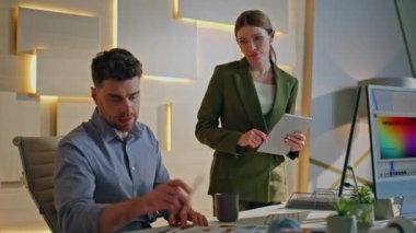 Ciddi bir yönetici elinde tablet bulunan kendine güvenen kadın CEO 'ya iş sonuçlarını gösteriyor. Yaratıcı iş yerinde proje sorunlarını tartışan iki profesyonel tasarımcı. Masadaki örneklere bakan tasarım uzmanları..