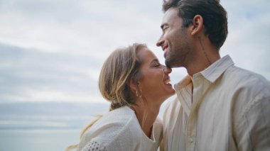 Gülen sevgililer okyanus manzaralı terasta eğleniyorlar. İspanyol seksi maço güzel bir kadını öpüyor bulutlu bir günde saçlarını okşuyor. Sevgili yeni evliler şehirde romantik bir buluşmanın tadını çıkarıyorlar.