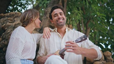 Ukulele 'de serenat yapan yakışıklı adam hafta sonu tatilinde kız arkadaşıyla dinleniyor. Müzikten hoşlanan romantik bir çift. Gitar tutan kaygısız Latin adam. Mutlu çift, iyi vakit geçiriyor.