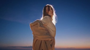 Kürk mantoyla akşam çöl dansı yapan çekici kız. Günbatımı kumullarında duygusal danslarda duygularını ifade eden ilham verici bir sanatçı. Uzun saçlı güzel bir bayan dansçı. 