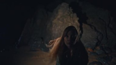 Duygusal kadın gece plajındaki parti portresinde vahşi dans. Sanatçı kollarını volkanik uçurumun arka planında hareket ettiriyor. Uzun saç dansçısı modern koreografi hareketlerini tek başına gösteriyor.