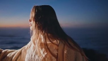 Günbatımında, arka planda şehvetli hareketler yapan baştan çıkarıcı dansçı. Okyanus sahilinde kürk manto giymiş çağdaş dans eden seksi kadın. Yaz gecesinde baştan çıkarıcı model fotoğraf makinesi.