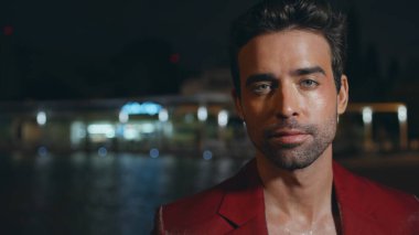 Gece sokakta kırmızı ceketli yakışıklı bir İtalyan 'ın portresi. Baştan çıkarıcı bakışları olan zengin, tıraşsız iş adamı bakışlı bir kamera. Şatafatlı trend adam haftasonu dinleniyor..