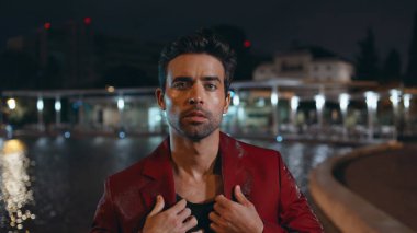 Yaz akşamları su havuzu kapanışı yapan yakışıklı bir model. Baştan çıkarıcı İtalyan adam kameraya bakıyor ve gece yarısı tek başına poz veriyor. Tıraşsız seksi bir adamın karanlık kasaba bölgesinde rahatlayan portresi..