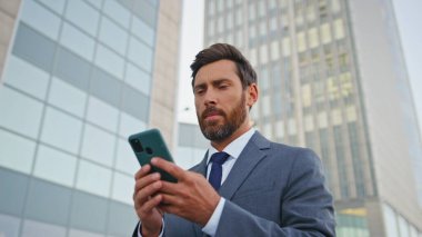 Finans müdürü akıllı telefon ekranı görünümlü uygulamayı tarıyor. Kendine güvenen iş adamı iş görüşmesinde cep telefonundan rapor okuyor. Sakallı yakışıklı patron cep telefonundan e-posta yazıyor.