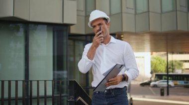 Kendine güveni tam bir ustabaşı konuşuyor. Walkie-talkie yürüyen şehir merkezini kapatıyor. Modern dış dünyada klasör tutan astlarına mesaj yazdıran ciddi bir mühendis. İnşaatta sıkı çalışan zarif bir adam.