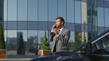 Zengin patron konuşuyor. İş yerinde arabaya biniyor. Kendine güveni tam bir işadamı güneşli caddede lüks bir otomobilin kapısını açıyor. Başarılı bir işletme sahibi açık havada akıllı telefon konuşuyor..