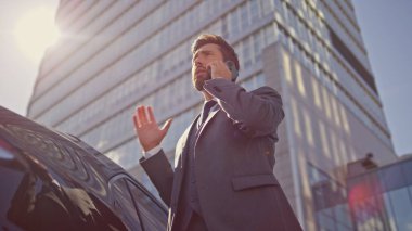 Yönetici, güneş ışığının altında ortağını arıyor. Kendine güvenen işadamı, lüks otomobilin yanında güneşli bir sokakta duran akıllı telefondan bahsediyor. Hareketli direktör telefonda iş eğitimi veriyor..
