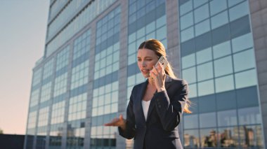 Sinirli girişimci akşam vakti caddede akıllı telefondan konuşuyor. Kapatın. Sinirli iş kadını, başarısızlığın astını aramasından endişeleniyor. Memnun olmayan bayan patron dışarıda cep telefonuyla sorun tartışıyor.