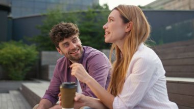 Neşeli çift parkta iletişimin keyfini çıkartıyor. Kahve fincanı tutan güzel bir kız. Gülümseyen sakallı adam yaz buluşmasında dinlenen kadını dinliyor. Sevgili eşlerimiz dışarıda dinleniyor..