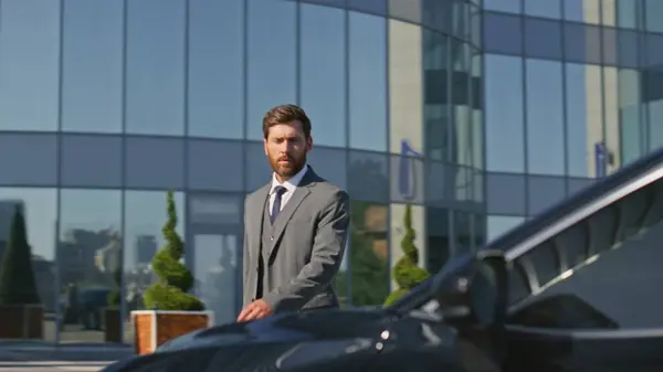 Ambitious businessman open car door going on work meeting at sunny street. Elegant boss walking to luxurious automobile sit down inside. Confident ceo manager coming to expensive auto premium class.