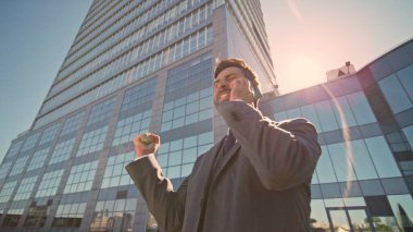 Neşeli adam, Sunny Street 'te duygusal hareketler yaparak akıllı telefonlardan konuşuyor. Heyecanlı sakallı iş adamı arıyor, dışarıdaki mutluluğu hissediyor. Mutlu patron sevinçli iş zaferi. Kamera hareket ediyor