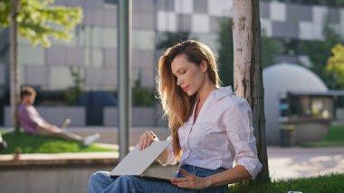 Şehir parkında elini uzatan serbest çalışan kız. Uzaktan kumandalı iş kadını işini bitiriyor. Bilgisayarı sokakta kapatıyor. Çekici, rahat, gözlerini kapayan, mutlu bir kadın. Müdür dışarıda mola verdi..